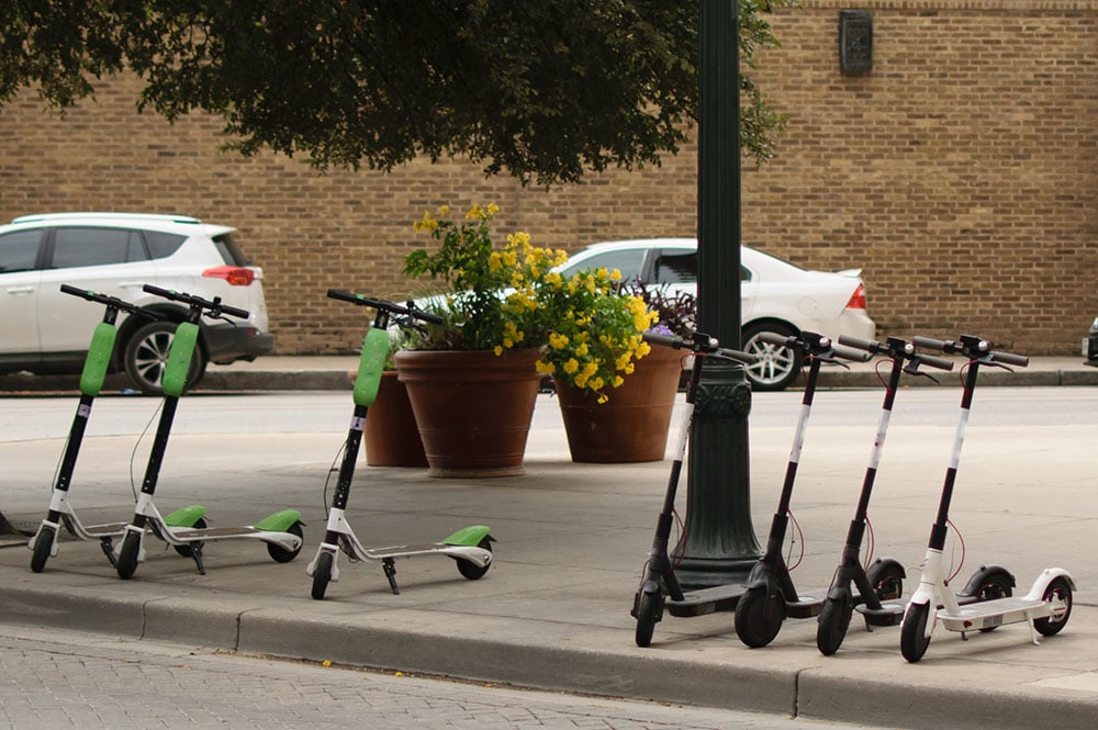 Scooters parked near flower pots.